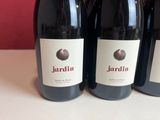 three bottles of red wine are lined up on a table