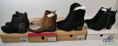 Quatre paires de bottines pour femmes se trouvent dans une boîte en carton