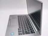 a silver laptop computer sitting on top of a white table