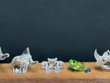 several figurines of elephants and other animals on a wooden table
