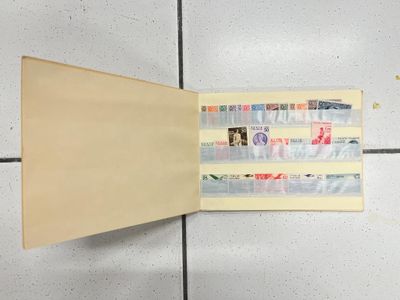 un dossier jaune orné de timbres, posé sur un sol carrelé