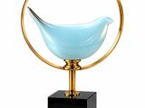 an image of a blue glass bird sitting on top of a wooden stand