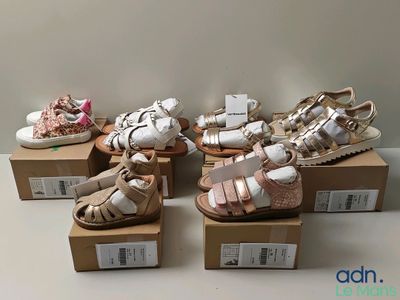 Plusieurs paires de chaussures pour bébé sont exposées dans une boîte