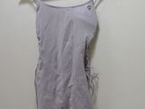 grey dress hanging on a hanger against a white wall