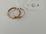 a pair of gold wedding rings on a white background