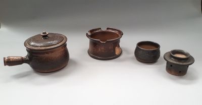 several small pots and cups are sitting on a white surface