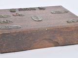 a small wooden box with metal buttons on it