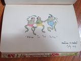 a drawing of two frogs in a box on a table