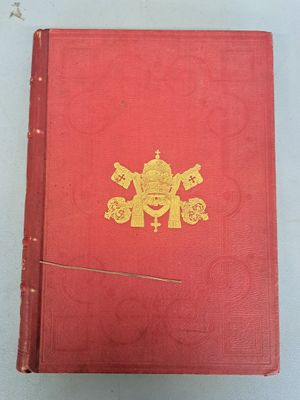 an old red book with a gold emblem on the cover