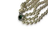 pearl necklace with emerald and white pearls on a white background