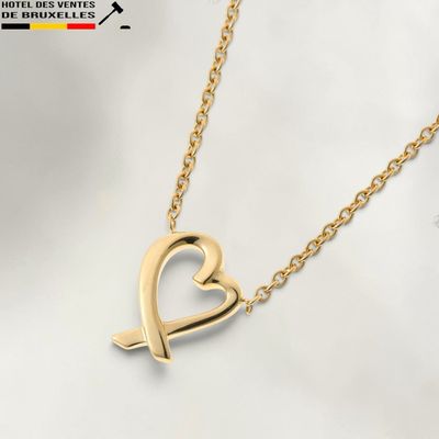 un collier en or orné d'un cœur et d'une flèche