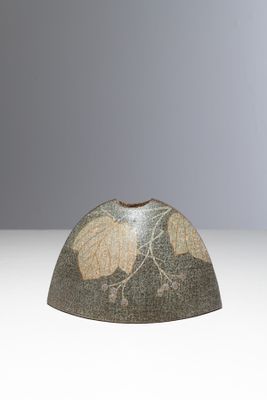 un petit vase orné d'un motif de feuilles
