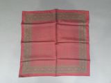 a close up of a pink and brown scarf on a white surface