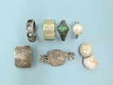 some silver and gold jewelry on a blue surface