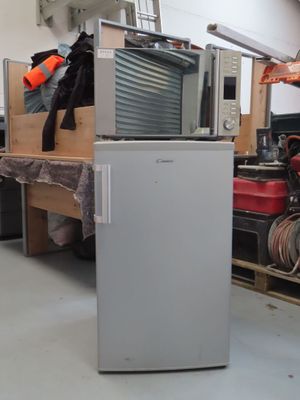 une photo d'un réfrigérateur dans un entrepôt, à côté d'autres appareils électroménagers