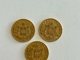 three gold coins sitting on top of a white surface