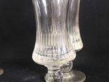 three glass vases sitting on a black surface