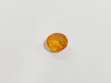 a yellow sapphire stone on a white surface