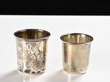 two silver cups sitting next to each other on a table