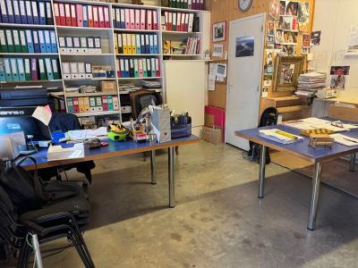 une pièce équipée d'un bureau, de chaises et d'un réfrigérateur
