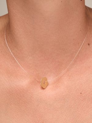 a close up of a woman wearing a necklace with a heart on it