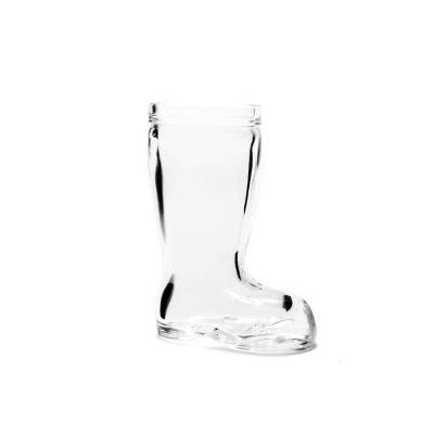 un vase en verre en forme de botte posé sur une surface blanche