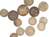 some coins are scattered together on a white surface
