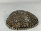an old silver plate with a decorative design on it
