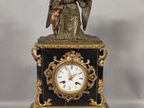 a statue of an angel holding a bird on top of a clock