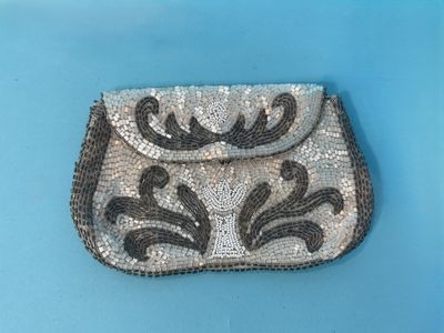 silver and black beaded purse on a blue surface