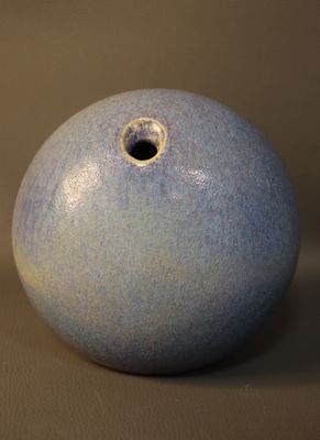 un vase bleu troué posé sur une table