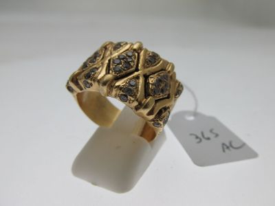 un gros plan d'une bague en or sertie de diamants noirs