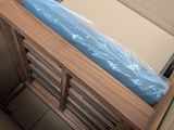 a bed in a box with a blue sheet on top of it