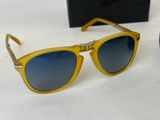 yellow sunglasses with blue lenses on a white surface with a box in the background