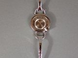 a silver wrist watch hanging on the wall