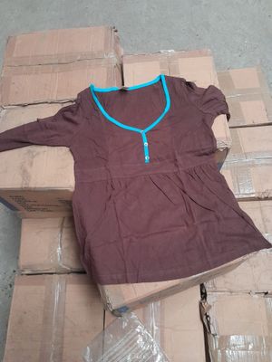 a brown shirt with a blue zipper on it sitting on a pile of boxes