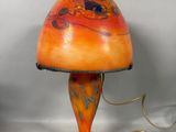 une lampe de table orange avec un pied noir et un abat-jour marron