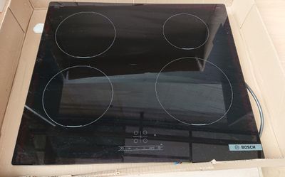 une image représentant une boîte contenant une plaque de cuisson noire
