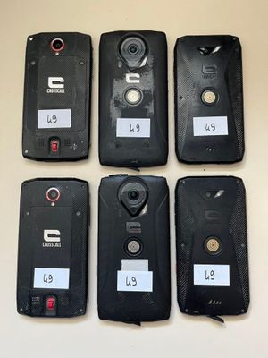 six cell phones are lined up on a table with labels on them