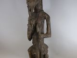 une vieille statue en bois d'un homme avec un chapeau sur la tête