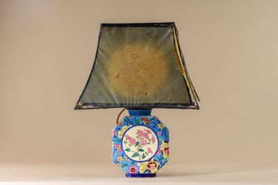 a blue and yellow vase with a black shade on it