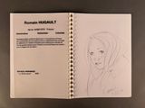 drawing of a woman ' s face in a book on a table