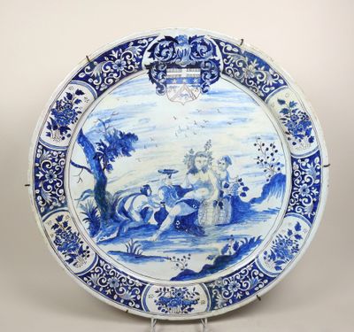 assiette bleue et blanche ornée d'une peinture représentant un homme et une femme dans un paysage