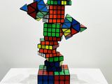 a colorful rubik cube sculpture on display on a white table