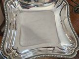 an antique silver plate with a decorative design on it