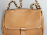 une image représentant un sac à main beige entouré d'une chaîne