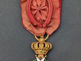 un gros plan d'une médaille ornée d'un ruban rouge sur fond gris