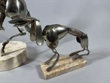 a silver statue of a horse and a dog on a marble base