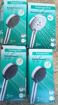 four boxes of hand held shower heads sitting on a wooden surface
