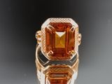 an image of a fancy ring with an orange stone